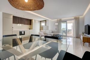 馬貝拉的住宿－Aqua Apartments Vento, Marbella，一间客厅,客厅内配有玻璃桌