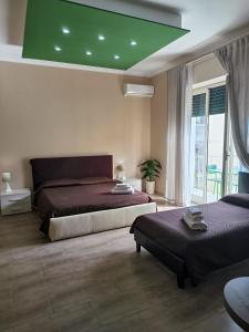 1 dormitorio con 2 camas y techo verde en Prestige B&B, en Catania