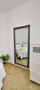 a mirror in a white room with a bed at 10 km From Airport in Vecindario
