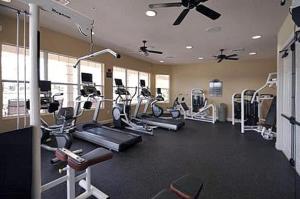 een fitnessruimte met diverse loopbanden en cardio-apparatuur bij Vista Cay 86 by Top Villas in Orlando