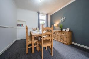 a dining room with a wooden table and chairs at Maindee Parade by Tŷ SA in Newport