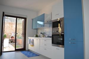 a kitchen with stainless steel appliances and a sliding glass door at Villa Oscar in Tropea