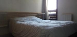 a bed sitting in a bedroom with a window at Les Isards Pied des pistes in Ax-les-Thermes +2 photos