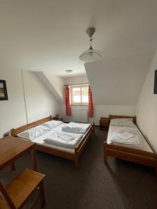 1 Schlafzimmer mit 2 Betten und einem Fenster in der Unterkunft Penzion U Šlechtů in Sněžné