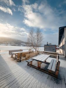 un groupe de bancs dans la neige sur un bâtiment dans l'établissement Voss Vandrarheim Hostel, à Vossevangen