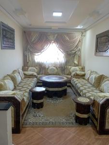 een woonkamer met een bank en een tafel bij appartement à larache in Larache