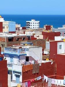a city with clothes drying on the roofs of buildings at appartement à larache in Larache