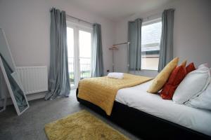 een slaapkamer met een bed en een groot raam bij Stunning sea views - Barry's Retreat by Tŷ SA in Barry