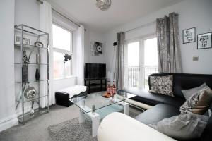 a living room with a couch and a glass table at Stunning sea views - Barry's Retreat by Tŷ SA in Barry