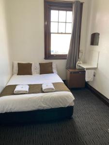 1 dormitorio con 1 cama con 2 toallas en The Exchange Hotel Blayney, en Blayney