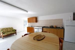 a kitchen with a table and a white refrigerator at Villa Lata in Marina San Gregorio