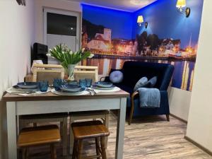 uma sala de estar com uma mesa e um sofá em Apartament z Tarasem em Ustka