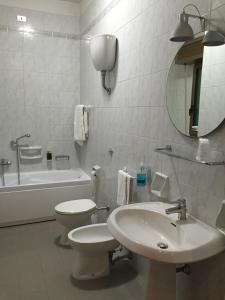 a bathroom with a sink and a toilet and a mirror at Hotel Barsotti in Brindisi