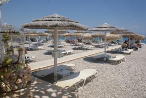a beach with chairs and umbrellas on the sand at Lemon Tree Family House in Vrachati