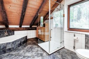 uma casa de banho com um chuveiro, uma banheira e um lavatório. em Chalet Wolf em Bayreuth