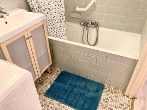 La salle de bains est pourvue d'une baignoire et d'un tapis bleu. dans l'établissement F3 au cœur du centre de Metz, à Metz 15 autres photos