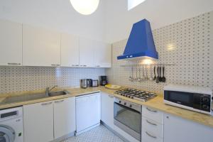 een keuken met witte kasten en een blauw plafond bij Villa Panorama in Praiano