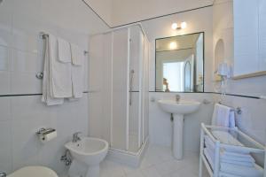 een witte badkamer met een wastafel en een spiegel bij Villa Panorama in Praiano +18 foto's