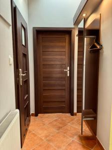 einen Flur mit zwei Holztüren und Fliesenboden in der Unterkunft Apartamenty U Anki in Zakopane