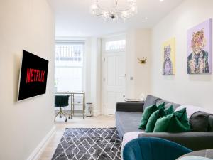 uma sala de estar com um sofá e um lustre em Urban getaway in the heart of South Kensington em Londres