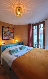 een slaapkamer met een groot bed en een kroonluchter bij L'Isle - Lofts & Lakes certified 5-stars in Annecy