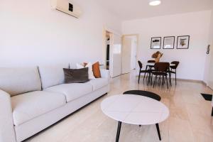 sala de estar con sofá blanco y mesa en Phaedrus Living Modern City View Flat Nafi en Limassol