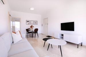 Sala de estar blanca con sofá blanco y mesa en Phaedrus Living Modern City View Flat Nafi en Limassol