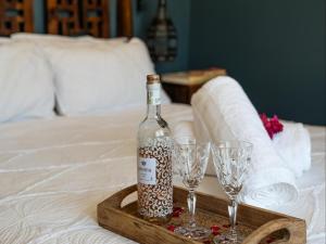 a bottle of wine on a tray with two wine glasses at Bella Bohemia Spa, Venue and Guest Farm in Roodeplaat