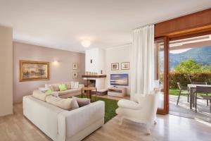 a living room with a white couch and a table and chairs at Ca' Le Terrazze With Pool in Garda