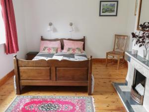1 dormitorio con cama con almohadas rosas y chimenea en House Of Ireland en Easkey