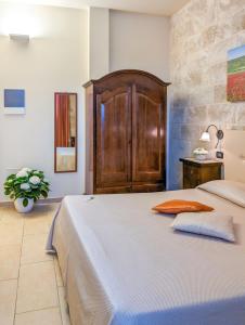 オートラントにあるAgriturismo Tenuta Sant'Emilianoのベッドルーム1室(大型ベッド1台、木製ヘッドボード付)
