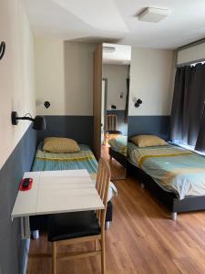 een kamer met 2 bedden en een tafel en stoelen bij Hotel Fauwater in Kasterlee