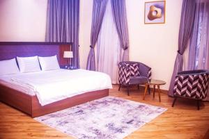 a bedroom with a bed and a table and a chair at Exquisite luxurious 2 bedroom Apartment. in Gwarinpa