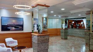 a lobby with a bar with white chairs and a painting on the wall at Hotel Las Vegas in Benidorm