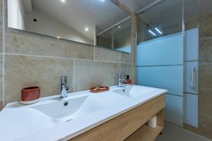 a bathroom with a white sink and a mirror at Ô DOMAINE DU ROUSSILLON 