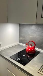 - Hervidor de té rojo sobre una estufa en LOFT URBANO, en Béjar