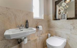 ein Badezimmer mit einem Waschbecken, einem WC und einem Spiegel in der Unterkunft Villa 10 min bus to Oxford train in Oxford