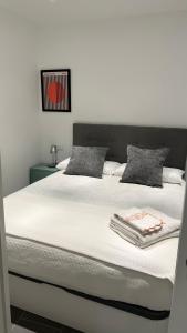 1 dormitorio con 1 cama grande con sábanas blancas en LOFT URBANO, en Béjar