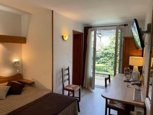 a hotel room with a bed and a desk with a computer at Hotel de Bourgogne in Saulieu