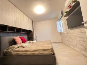 バーリにあるi giardini di edicartのベッドルーム1室(大型ベッド1台、赤い枕付)