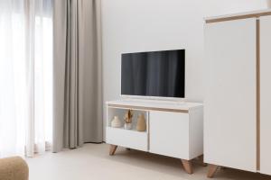 a living room with a tv on a white cabinet at Apartamento Don Algodón Grau in Gandía