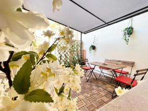 un patio con mesa, sillas y flores blancas en i giardini di edicart, en Bari