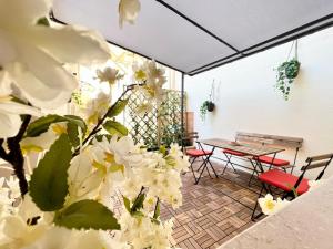 a patio with a table and chairs and white flowers at i giardini di edicart in Bari