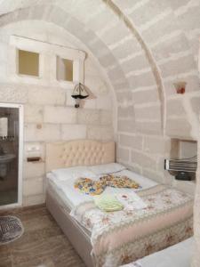 - une chambre avec un lit dans un mur en pierre dans l'établissement ULAŞ CAVE HOTEL, à Ürgüp
