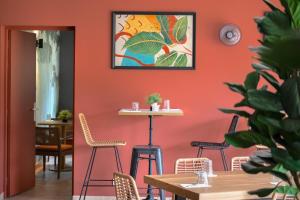 ペルヌ・レ・フォンテーヌにあるHôtel La Pernaのオレンジ色の壁のレストラン、テーブルと椅子