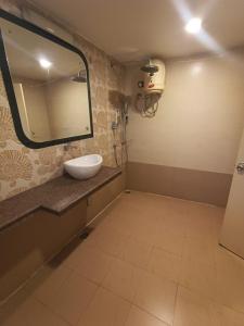 een badkamer met een wastafel en een spiegel bij Diviyum Manor in Port Blair