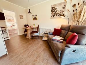 a living room with a couch and a table at SEGELund - Zeit für uns- ruhige und sonnige Ferienwohnung mit Terrasse und Garten nahe Strand und Ostsee in Schönhagen