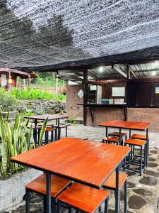 un groupe de tables et de bancs dans un restaurant dans l'établissement Sembalun Kita Cottage, à Sembalun Lawang