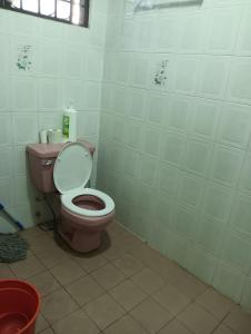 baño con aseo rosa en una habitación en Bintulu AirBnB Homestay en Bintulu