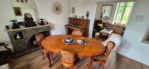 sala de estar con mesa de madera y chimenea en Demeures ressourçantes - Le Vallon en Saint-Martin-de-Saint-Maixent